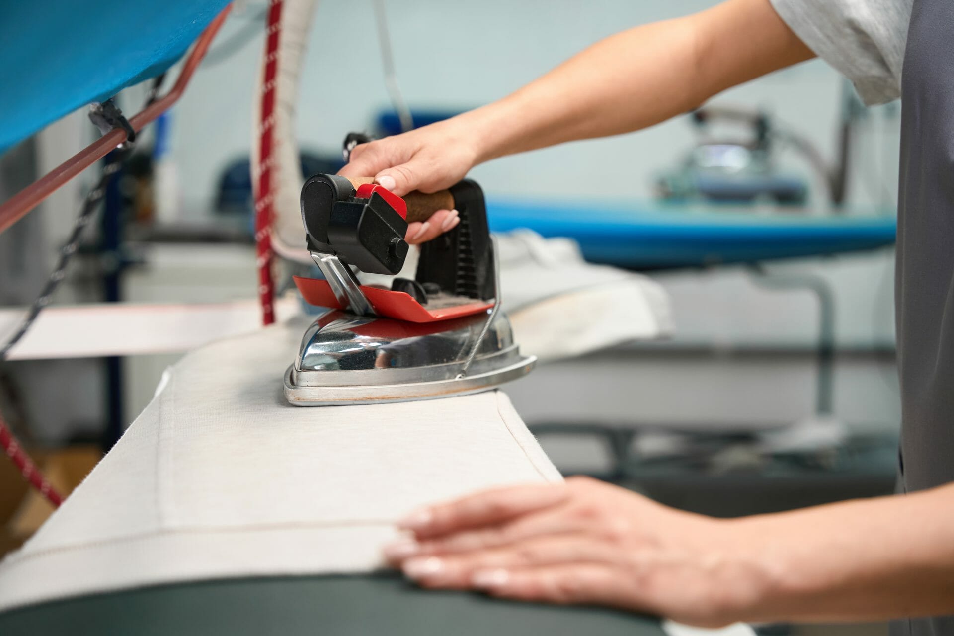 A woman is sewing a pair of jeans on a sewing machine.