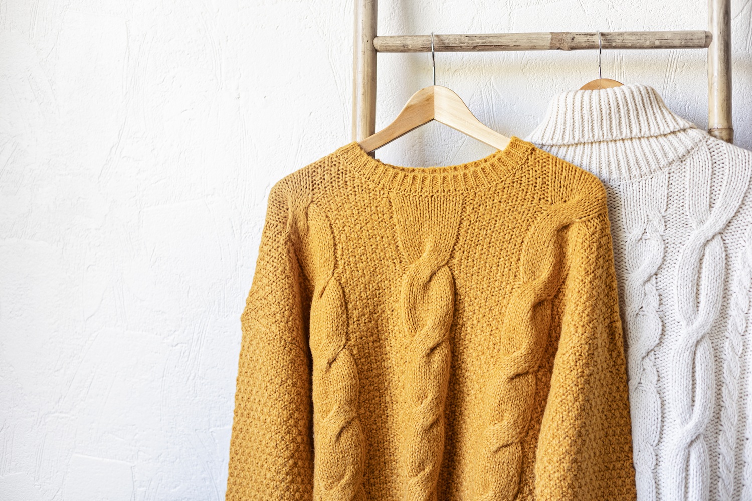 Warm autumn sweaters on hangers. Comfort knitwear for cold days